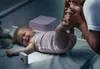 A parent is kissing a baby's foot while the baby lies on a changing table. Voir les images du produit