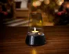 A candle lantern speaker sits on a wooden table outdoors at night, with blurred lights in the background. Anteprima dell’immagine prodotto