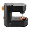 A black sewing machine with orange accents, shown from a side-angle with a small piece of brown fabric under the needle. Náhled obrázku produktu