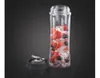 A blender cup filled with strawberries, blueberries, and ice, next to its blade attachment, against a dark background. Produktbild-Vorschau