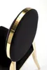 A close-up view of the back of a black chair with a gold trim. Podgląd zdjęcia produktu