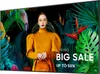 A woman in an orange dress stands in front of a lush green tropical background with text advertising a sale. Náhľad obrázku produktu