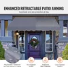 A retractable patio awning is shown installed over a front door, with rain depicted falling. Podgląd zdjęcia produktu