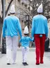 Three people dressed as Smurfs walk down a street. Produktbild-Vorschau