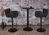 Two dark brown bar stools and a small black bar table are set against a stone wall background. Náhled obrázku produktu