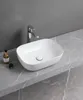 A white ceramic vessel sink with a chrome faucet sits on a gray marble countertop. Náhled obrázku produktu