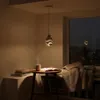 A cozy reading nook with a steaming mug of coffee, books, and a blanket next to a window at dusk. Náhled obrázku produktu