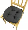 A round, dark gray seat cushion with ties is placed on a light wooden chair. Produktbild-Vorschau