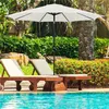 A white patio umbrella shades two lounge chairs next to a swimming pool. Produktbild-Vorschau