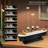 A model of the Titanic ship is shown emitting smoke, with a series of smaller images on the left displaying different light colors. The text suggests enjoying colorful lights for a romantic atmosphere. Produktbild-Vorschau