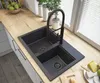 A modern kitchen sink with a black faucet, set on a wooden countertop next to a window. Podgląd zdjęcia produktu