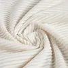 A close-up view of a beige fabric with a ribbed texture, folded and swirled. Produktbild-Vorschau