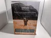 A box with a marketing image on it, showing a person holding a baby in a field with mountains in the background. Produktbild-Vorschau