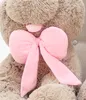 A close-up shot of a large, fluffy teddy bear with a pink bow. Voir les images du produit