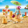 Two children playing with sand toys on a beach. Anteprima dell’immagine prodotto