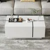 A white high-gloss coffee table with black accents, decorated with a bottle of liquid, two glasses, a small wooden block with a candle, and a book. A green plant is placed in a small vase on the table. The table is placed on a patterned rug in front of a l Voir les images du produit