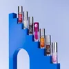 A collection of lip oil products arranged on a blue tiered display. Podgląd zdjęcia produktu