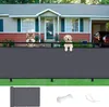 Two dogs are peeking over a dark gray privacy screen in front of a house. Produktbild-Vorschau