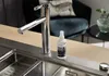 A kitchen sink with a faucet and a cleaning spray bottle. Produktbild-Vorschau