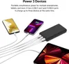 A black power bank is shown charging three devices: two smartphones and a tablet. Produktbild-Vorschau