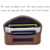 A brown signal-blocking pouch with two cell phones inside, one yellow and one dark blue. Text above explains how to use it. Produktbild-Vorschau