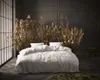A bedroom scene with a bed decorated with dried plants. Produktbild-Vorschau