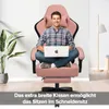 A man sitting in a pink gaming chair with a laptop. Produktbild-Vorschau