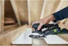 A person is using a Festool sander on a wooden surface in a construction setting. Voir les images du produit
