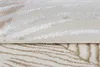 A close-up view of a folded rug with a striped pattern. Produktbild-Vorschau