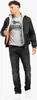 A man wearing a black bomber jacket over a gray Lonsdale t-shirt and dark wash jeans, standing against a white background. Produktbild-Vorschau