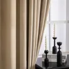 A close-up view of beige velvet curtains with black candle holders and candles on a table in front of a window. Anteprima dell’immagine prodotto