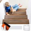 A boy and a puppy are on a wooden staircase, with a squeegee and tape in the foreground. Produktbild-Vorschau