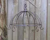 A metal hanging basket against a wooden fence. Produktbild-Vorschau