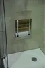 A wall-mounted shower seat in a shower stall. Podgląd zdjęcia produktu