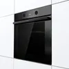 A built-in oven is shown in a modern kitchen setting, integrated into white cabinetry. Voir les images du produit