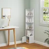 A white corner shelf unit with books and decorative items is placed next to a desk with a lamp and a framed picture on the wall. Produktbild-Vorschau