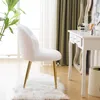 A white fluffy chair with gold legs sits on a white rug in front of a window with sheer curtains and green drapes. A white vanity table with makeup is to the right. Podgląd zdjęcia produktu