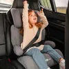 A young girl is sitting in a car seat in the back seat of a car. Produktbild-Vorschau