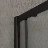 A close-up view of a shower enclosure's frame and glass against a textured wall. Anteprima dell’immagine prodotto