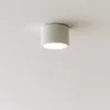 A white cylinder-shaped ceiling light fixture is mounted on a white ceiling. Náhled obrázku produktu