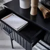 A close-up view of an open black console drawer with a stack of envelopes inside. Produktbild-Vorschau