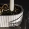 A close-up of a white candle holder with dried orange slices and moss. Produktbild-Vorschau