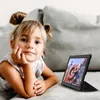 A young girl is lying on a couch, looking at a tablet. Produktbild-Vorschau