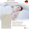 A woman sleeping peacefully on a pillow, with a folded sheet in the foreground and marketing text overlay. Produktbild-Vorschau