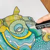 A hand is coloring a detailed drawing with a marker. Produktbild-Vorschau