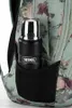 A close-up shot of a black thermos with a silver lid, placed in a side pocket of a floral patterned backpack. Produktbild-Vorschau