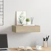 A floating shelf with decorative items on it, placed above a desk with a laptop and books. Produktbild-Vorschau