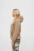 A woman is shown from the side wearing a camel-colored teddy fleece jacket and camouflage pants against a white background. Produktbild-Vorschau