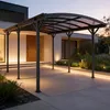 A modern carport structure in front of a house at dusk, with integrated lighting. Produktbild-Vorschau