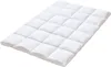 A white quilted mattress topper is shown from a diagonal angle against a white background. Náhled obrázku produktu